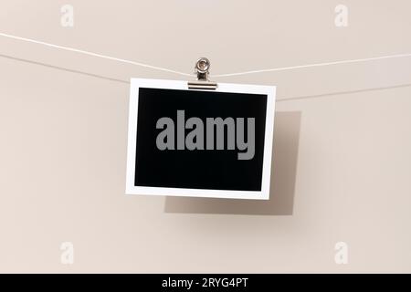 Cornice fotografica istantanea vintage vuota appesa su una corda. Modello Foto Stock