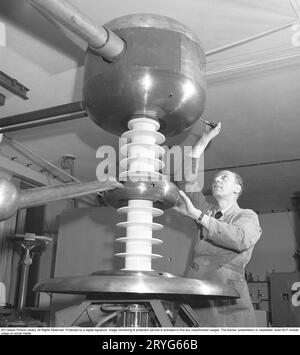 Uomo e macchina negli anni '1940 Un uomo è visto in una stanza con una costruzione tecnica insolita di scopo sconosciuto. Si vede regolare qualcosa con un cacciavite. Foto scattata al KTH Royal institute of Technology. Svezia 1945 Kristoffersson rif Y54-2 Foto Stock