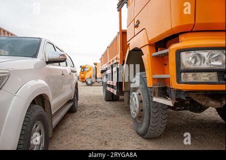 Primo piano di un dumper arancione in un'area di costruzione Foto Stock