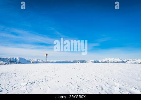 Una torre radio con due piatti satellitari sulla cima di una montagna innevata, Andorra Foto Stock