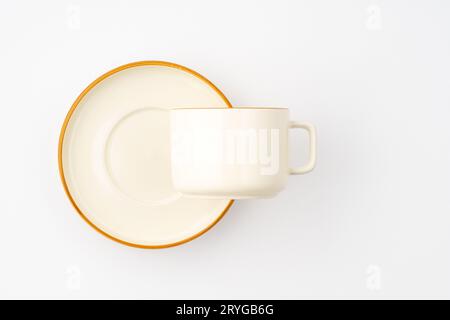 Un set di piastra e tazza in ceramica bianca e marrone su sfondo bianco. Vista dall'alto Foto Stock