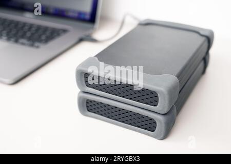 Primo piano dello storage dei dischi rigidi esterni collegati a un moderno computer portatile Foto Stock