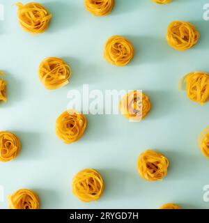 Pasta art con tagliatelle su sfondo blu Foto Stock
