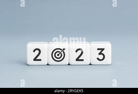 concetto di obiettivo di 2023 anni. Blocchi bianchi con 2023 numero e icona obiettivo su sfondo blu. Spazio di copia Foto Stock