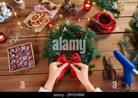 donna che fa abete wreath natale a casa Foto Stock