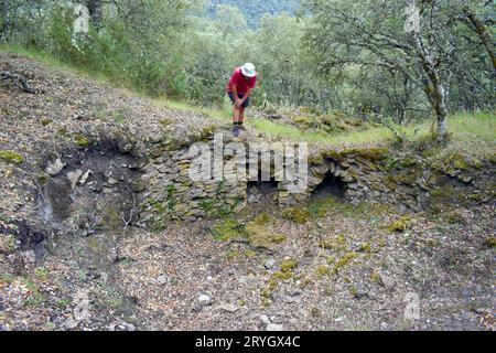 Un escursionista osserva un antico forno a calce a Los Castros de lastra risalente all'età del ferro. Valdegov’a.. Alava. Paesi baschi. Spagna. Foto Stock