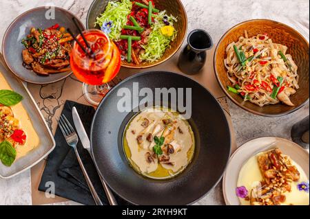 Un set di piatti della cucina thailandese su un tavolo in un ristorante con un cocktail. Vista dall'alto. Foto di alta qualità Foto Stock