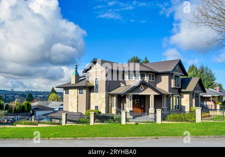 Grande casa residenziale su sfondo bluesky con recinzione in metallo di fronte Foto Stock