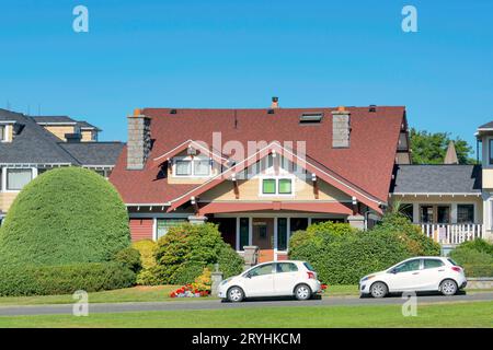 Casa residenziale di lusso con due piccole auto parcheggiate di fronte Foto Stock