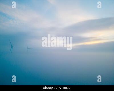 Vista aerea delle turbine eoliche o dei mulini a vento in fabbrica industriale con nebbia. Energia, energia pulita verde sostenibile, ed en Foto Stock