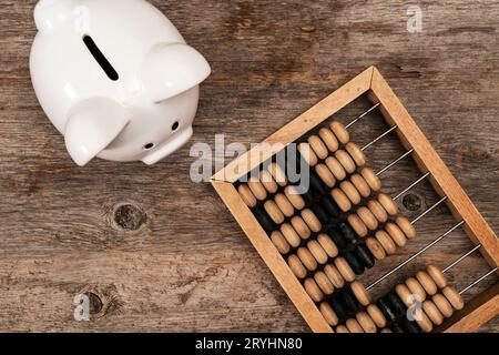 Salvadanaio e abaco d'epoca e su sfondo di legno Foto Stock