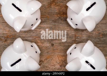 Quattro salvadanaio sul vecchio sfondo di legno Foto Stock