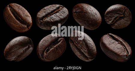 I chicchi di caffè cadenti sono isolati su sfondo nero Foto Stock