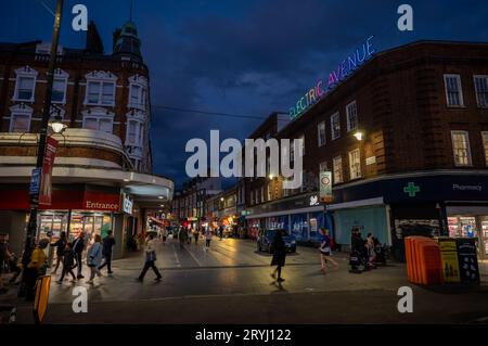 Brixton, Londra, Regno Unito: Electric Avenue a Brixton di notte. Vista da Brixton Road con la colorata insegna al neon Electric Avenue. Foto Stock