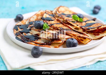 Pancake con salsa al cioccolato e mirtilli. Foto Stock