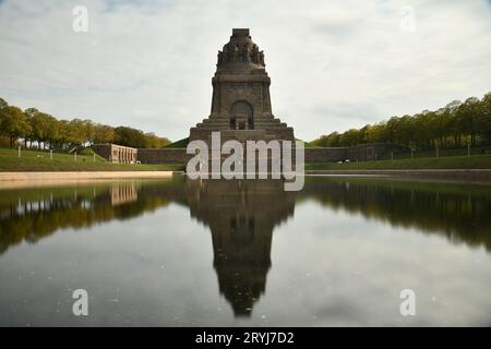 Stagno che riflette il Monumento alla Battaglia delle Nazioni a Lipsia, in Germania, contro un cielo nuvoloso Foto Stock