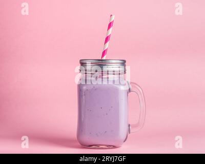 Frullato di mirtillo in vetro di vaso di mason su rosa Foto Stock