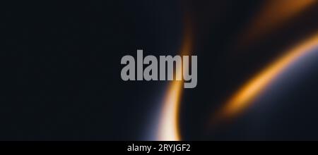 Fiamma dorata su sfondo grigio scuro, onde arancioni sfocate astratte su rumore scuro, spazio di copia Foto Stock