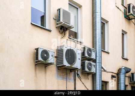 I vecchi condizionatori d'aria sono appesi alla facciata del vecchio edificio Foto Stock