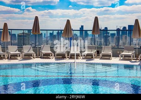 Le sedie a sdraio intorno alla piscina Foto Stock