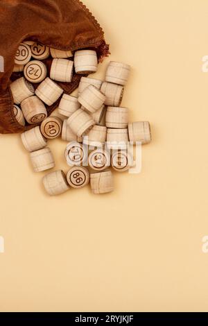 Fusti di lotto in legno con sacchetto marrone su sfondo beige. Foto Stock