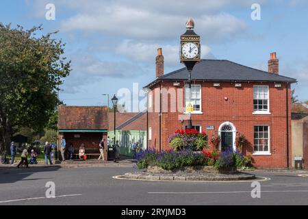 Bishop's Waltham, Hampshire, Inghilterra, Regno Unito, vista sulla strada di St George's Square e orologio nella storica città mercato, in una giornata di sole Foto Stock