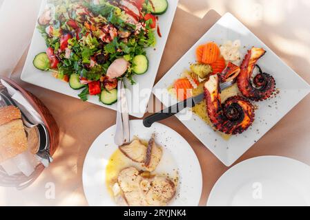 Tentacoli di polpo grigliati, pesce e insalata con cozze. Foto Stock
