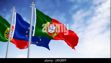 Le bandiere del Portogallo sventolano con la bandiera dell'Unione europea in una giornata limpida Foto Stock