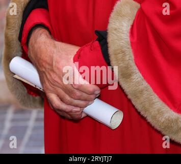 elegante abito rosso con inserti in morbida pelliccia e pergamena in mano Foto Stock