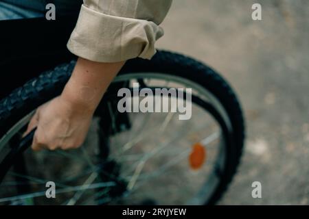 Donna con disabilità seduta in sedia a rotelle nel parco. Foto di alta qualità Foto Stock