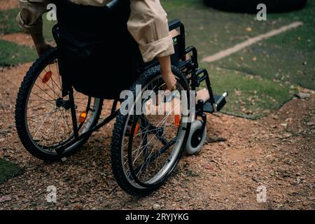 Donna con disabilità seduta in sedia a rotelle nel parco. Foto di alta qualità Foto Stock