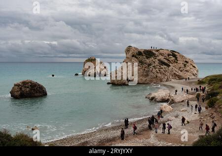 Turisti persone sulla costa rocciosa punto di riferimento della roccia di Afrodite spiaggia nella zona di Paphos a Cipro Foto Stock