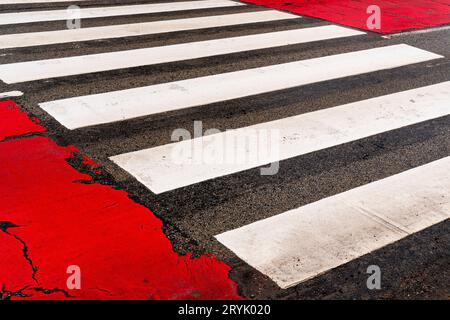 Segnaletica dei passerelle e gomma rossa sulla strada Foto Stock