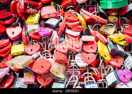 Verona, Italia - Giugno 2022: Sfondo di chiuse a forma di cuore su una parete, simbolo dell'amore per sempre. Foto Stock