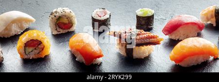 Panorama sushi. Nigiri con anguilla, salmone e tonno, involtino con avocado, ecc. Foto Stock