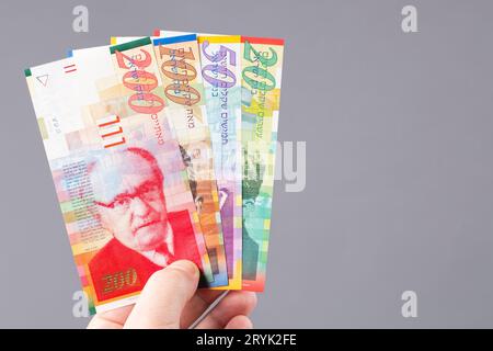 Soldi israeliani in mano Foto Stock