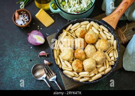 Pasta italiana. Spaghetti con polpette in salsa di formaggio su fondo di pietra scura o calcestruzzo. Spazio di copia. Foto Stock