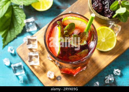 Bevanda rinfrescante estiva con mora, menta, lime e ghiaccio, mojito o blackberry soda, su un tavolo di pietra scura. Foto Stock