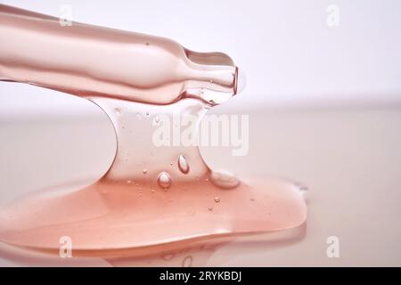 Pipetta con primo piano cosmetico rosa viscoso. Foto Stock