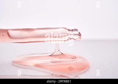 Pipetta con primo piano cosmetico rosa viscoso. Foto Stock
