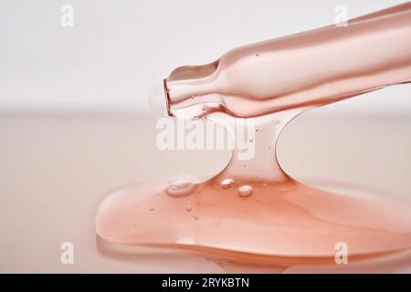 Pipetta con primo piano cosmetico rosa viscoso. Foto Stock
