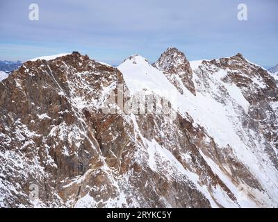 VISTA AEREA. Massiccio del Monte Rosa con sinistra a destra; Punta Gnifetti, Punta Zumstein, Dufourspitze (il più alto con 4634 metri), Nordend. Piemonte, Italia. Foto Stock