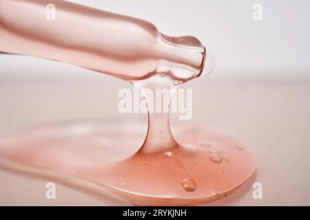 Pipetta con primo piano cosmetico rosa viscoso. Foto Stock