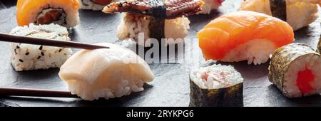 Sushi con bacchette panoramiche. Nigiri di pesce bianco e salmone Foto Stock