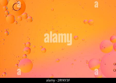 Sfondo astratto rosa arancio con superficie d'acqua in cerchi d'olio Foto Stock