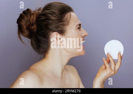 donna sorridente di 40 anni con tampone di cotone su sfondo blu. Foto Stock