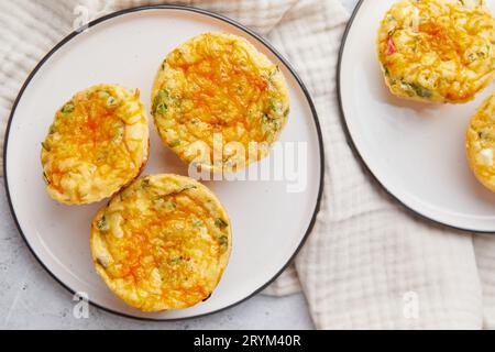 Gustosi muffin con uova, formaggio feta, cheddar e spinaci su sfondo chiaro Foto Stock