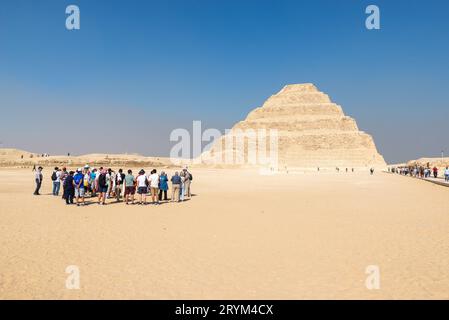 Un gruppo di turisti che visitano la piramide a gradoni di Djoser, Saqqara, Egitto Foto Stock