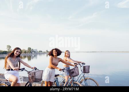 Adolescenti di diverse nazionalità e aspetto in bicicletta percorrono una strada cittadina Foto Stock