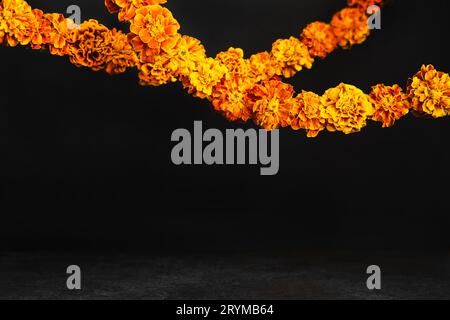 Fiori di calendula ghirlande su nero. Dia de los muertos giorno, giorno dei morti o sfondo di halloween, spazio copia Foto Stock